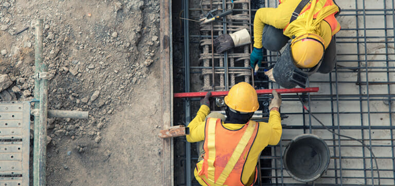 Construction employees at work fixing a grid